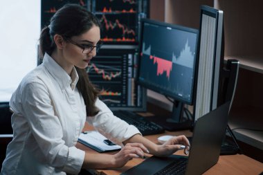 Borsa simsarları bir ofiste birden fazla ekran ekranı olan bir konuşma yapıyorlar..