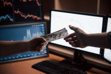 O parayı akıllıca kullan. Modern ofiste üzerinde ekranlar ve grafikler olan maaş günü.