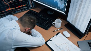 Stres altındayım çünkü beklenmeyen bir hata. Ofiste çalışan adamın indeks grafiklerinde birden fazla bilgisayar ekranı var..