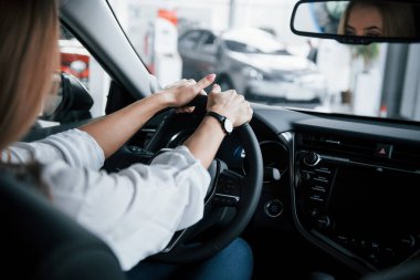 Ellerini direksiyona koy. Yeni arabasında oturan güzel sarışın kız..