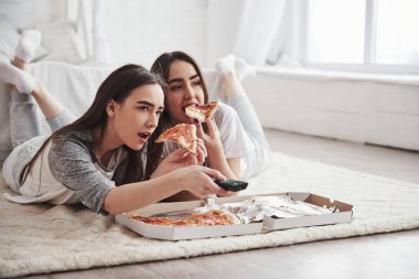 - Boş zaman. Gündüz vakti güzel yatak odasının zemininde yatarken TV izlerken pizza yiyen rahibeler..