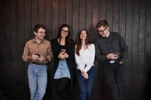 Smilende Sammen Ungdom Står Mod Sort Træmur Gruppe Venner Tilbringer - Stock-foto