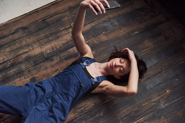 Faccio Selfie Ragazza Uniforme Blu Lavoro Sdraiato Sul Pavimento Legno — Foto Stock