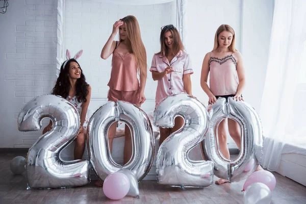 四个穿着粉色和白色衣服的女孩站在那里 手里拿着银色的气球 新年快乐的概念 — 图库照片