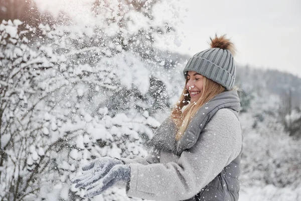 Wesoła Dziewczyna Ciepłych Ubraniach Rzucając Śnieg Zewnątrz Pobliżu Pięknego Lasu — Zdjęcie stockowe