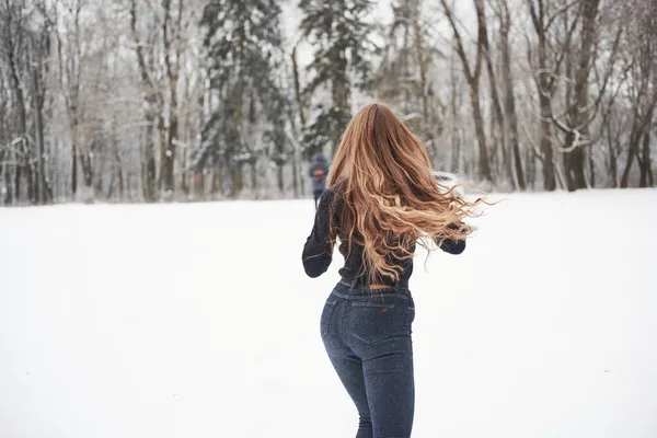 あそこに車がある 冬には森の近くで車に長い髪の少女の後部ビューが実行されます — ストック写真