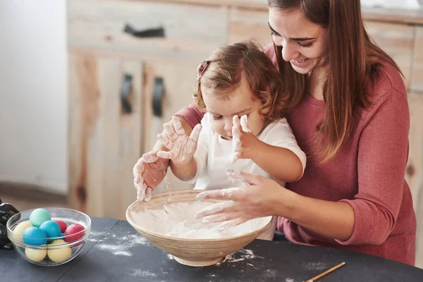 애들은 밀가루를 가지고 어머니는 부활절 휴일에 달걀에 페인트를칠 가르친다 — 스톡 사진