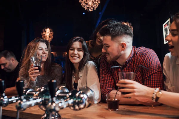 Friendly conversation. Beautiful youth have party together with alcohol in the nightclub.