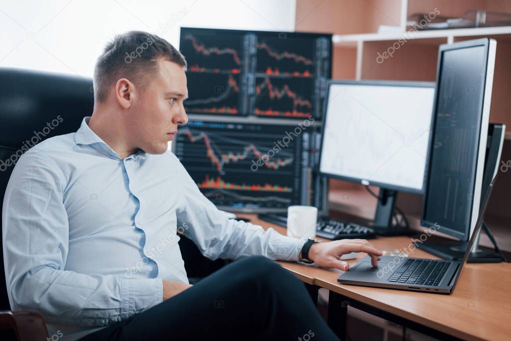 Too many things needed to be successful. Man working online in the office with multiple computer screens in index charts.