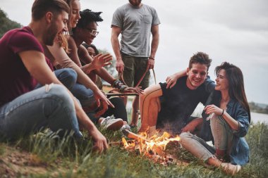 Sıcak bir atmosfer. Bir grup insan sahilde piknik yapıyor. Arkadaşlar hafta sonu eğlenir..