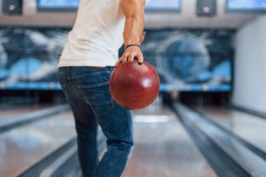 Hafta sonu aktiviteleri. Kulüpte bowling oynayan sıradan giyinmiş bir adamın arka parçacık görüntüsü..