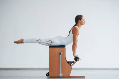 Omurga egzersizi. Zayıf vücutlu, kendine güvenen, genç, sportif bir kadın..