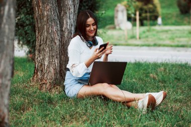 Bir sürü cihaz. Genç bir kadın hafta sonu geçirir ve gündüz vakti parkta oturur..