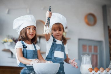 Beyaz şef üniformalı aile çocukları mutfakta yemek hazırlıyorlar..