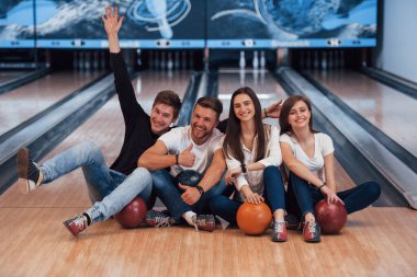 Jestler gösteriyor. Genç neşeli arkadaşlar hafta sonları bowling kulübünde eğleniyorlar..