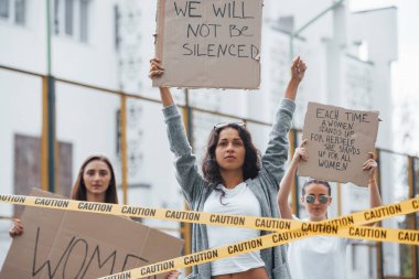 Bizi susturamazsın. Bir grup feminist kadın dışarıda hakları için protesto yapıyor..