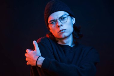 Sakin ve sessiz. Stüdyo karanlık stüdyoda neon ışıkla çekiliyor. Ciddi bir adamın portresi..