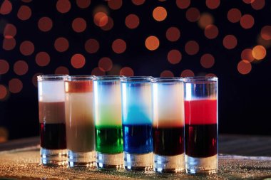 Seçimini yap. Kokteyller hazır. Gece kulübündeki ahşap masada. Güzel ışıklandırma..