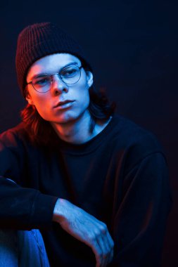 Modern gençlik. Stüdyo karanlık stüdyoda neon ışıkla çekiliyor. Ciddi bir adamın portresi..