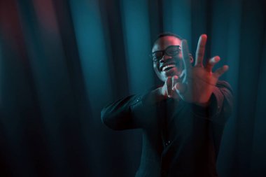 İlginç kirişler. Fütürist neon ışıkları. Stüdyodaki Afrikalı Amerikalı genç adam..