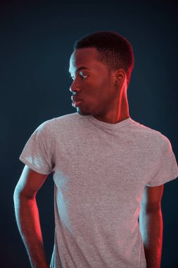Fütürist neon ışıkları. Stüdyodaki Afrikalı Amerikalı genç adam..
