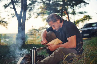 Hafta sonu kamp ateşinin yanında siyah gömlekli bir adam vardı..