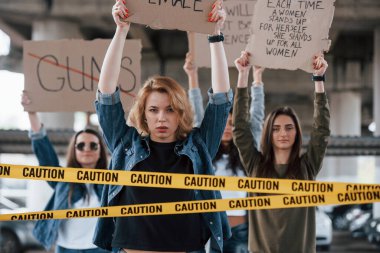 Gel bize katıl. Bir grup feminist kadın dışarıda hakları için protesto yapıyor..