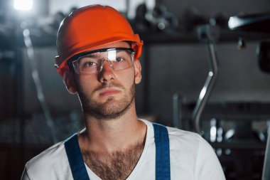 Metalurji fabrikasında koruyucu miğfer ve gözlüklü bir mühendisin portresi..