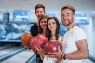 Samimi gülümsemeler. Genç neşeli arkadaşlar hafta sonları bowling kulübünde eğleniyorlar..