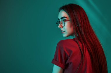 Dikiz aynası. Stüdyo içeride neon ışıkla çekiliyor. Güzel bir genç kızın portresi.