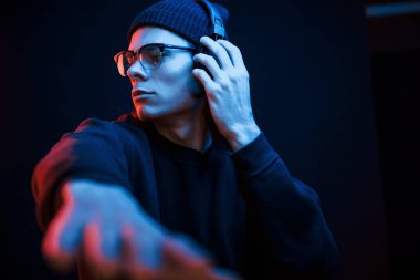 Parti zamanı. Stüdyo karanlık stüdyoda neon ışıkla çekiliyor. Ciddi bir adamın portresi..