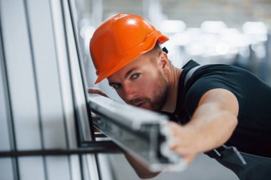 Nesnelerin uzunluğunu ölçüyorum. Fabrikada sanayi işçisi. Turuncu şapkalı genç teknisyen..