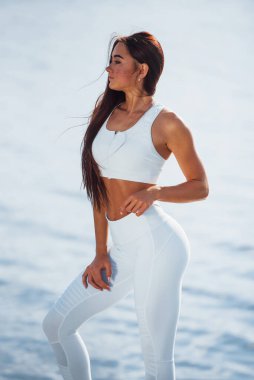 Kameraya poz veriyorum. İnce vücutlu genç fitness kadını açık havada..
