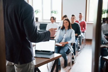 Neşeli bir ruh hali. Gündüz vakti modern sınıftaki iş konferansında bir grup insan.