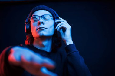 Müziği açıyorum. Stüdyo karanlık stüdyoda neon ışıkla çekiliyor. Ciddi bir adamın portresi..