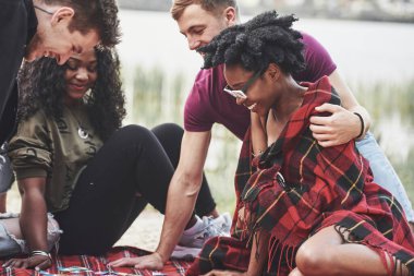 Arkadaşlarla güzel bir gün. Bir grup insan sahilde piknik yapıyor..