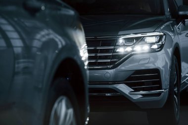 Güçlü farlar. Gündüz vakti park edilmiş modern lüks arabaların parçacık görüntüsü.