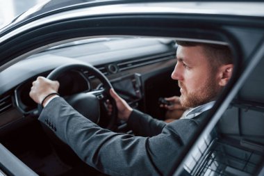 Açılmış pencereden bakıyorum. Otomobil kuaföründe yeni araba deneyen sevimli başarılı çift..