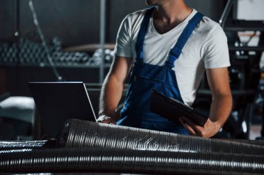 Her şey yolunda mı diye kontrol eder. Üniformalı adam prodüksiyonda çalışıyor. Endüstriyel modern teknoloji.