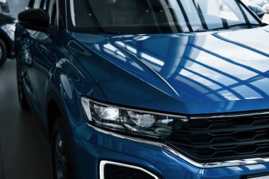 Yepyeni modern mavi arabanın ön tarafı. Galeriye park ettim. Farlardaki yansıma..