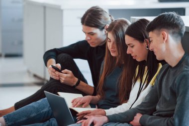 Bir proje için ortak çaba. Modern ofiste çalışan günlük kıyafetli bir grup genç..