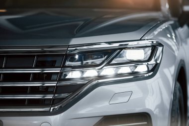 Başarılı insanlar için. Gündüz vakti park edilmiş modern lüks beyaz arabanın parçacık görüntüsü.