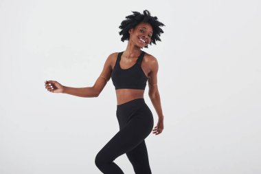 İyi yürüyüşler. Stüdyoda beyaz arka planda güzel bir Afro-Amerikan kadın var..