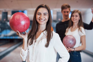 Dişli gülümseme. Genç neşeli arkadaşlar hafta sonları bowling kulübünde eğleniyorlar..