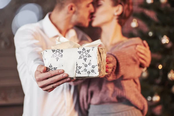 ギフトボックスを保持しながらキス かわいい人たち 新年を祝う素敵なカップル装飾された部屋で — ストック写真