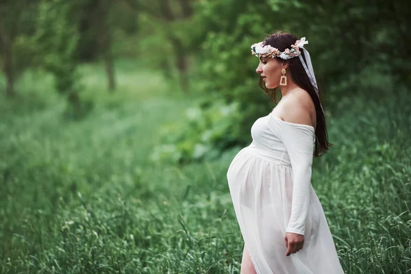 期待してた ドレスを着た美しい妊婦は屋外で散歩をしています ポジティブブルネット — ストック写真