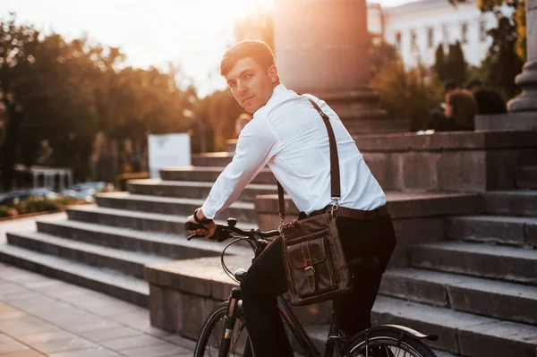 後ろの景色 黒い自転車の正式な服を着たビジネスマンが街にいます — ストック写真