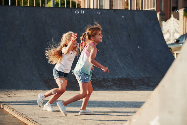 Having fun with bubbles. Leisure activities. Two little girls having fun in the park.