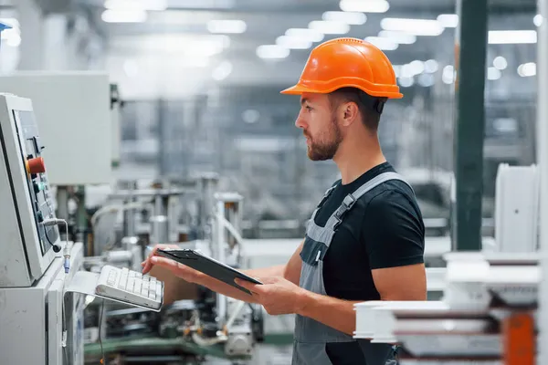 Ránéz Berendezésekre Jegyzetel Ipari Munkás Gyárban Fiatal Technikus Narancssárga Keménykalapban — Stock Fotó