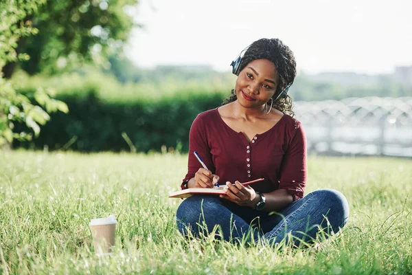 Γράφοντας Σημειωματάριο Χαρούμενη Αφροαμερικανή Στο Πάρκο Καλοκαίρι — Φωτογραφία Αρχείου